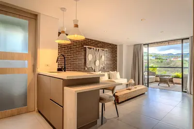 a kitchen and living room with a table and a couch at Villa reservoir view in Guatapé
