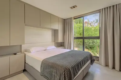 a bedroom with a bed and a large window at Villa reservoir view in Guatapé