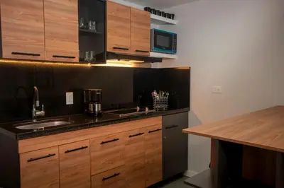a kitchen with wooden cabinets and a sink and a microwave at Céntrico Apartaestudio en el Parque de Poblado in Medellín