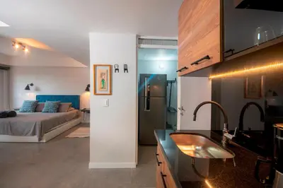 a kitchen and a bedroom with a bed and a sink at Céntrico Apartaestudio en el Parque de Poblado in Medellín