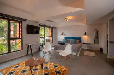 a bedroom with a bed and a table and chairs at Céntrico Apartaestudio en el Parque de Poblado in Medellín