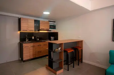 a kitchen with a counter and a table in a room at Céntrico Apartaestudio en el Parque de Poblado in Medellín