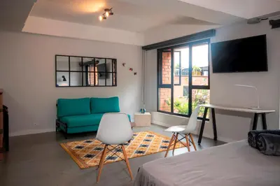 a living room with a blue couch and a table at Céntrico Apartaestudio en el Parque de Poblado in Medellín
