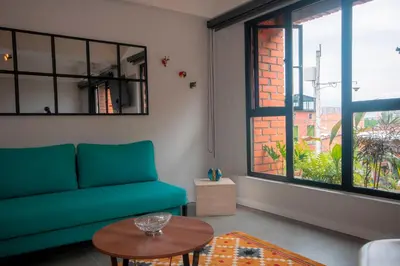 a living room with a blue couch and a table at Céntrico Apartaestudio en el Parque de Poblado in Medellín