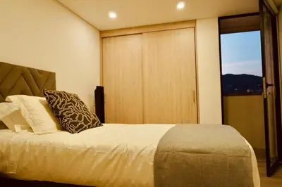 a bedroom with a bed and a sliding glass door at Deluxe apartment with an incredible view in envigado in Envigado