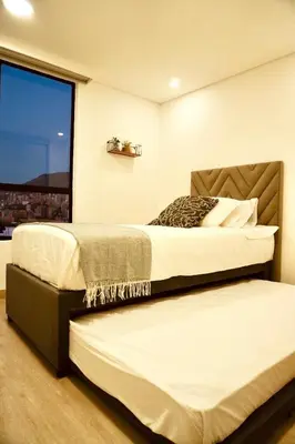two beds in a room with a window at Deluxe apartment with an incredible view in envigado in Envigado