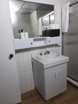 a white bathroom with a sink and a mirror at Modern, Comfortable, Spacious & Central in Manizales