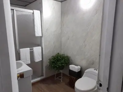 a white bathroom with a toilet and a sink at Modern, Comfortable, Spacious & Central in Manizales