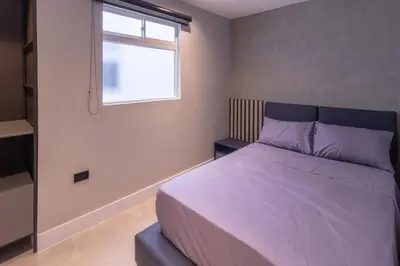 a bedroom with a bed with purple sheets and a window at Luxury penthouse with Jacuzzi and AC, North Medellin in Medellín