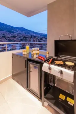 a kitchen with a grill on a balcony at Luxury penthouse with Jacuzzi and AC, North Medellin in Medellín