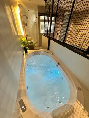 a large bath tub in a room with a window at Luxury penthouse with Jacuzzi and AC, North Medellin in Medellín
