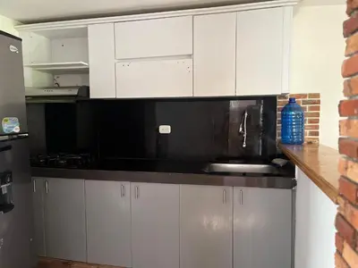 a kitchen with white cabinets and a black microwave at Cabaña en la CRISTALINA San Rafael embrujo de aguas cristalinaa in San Rafael