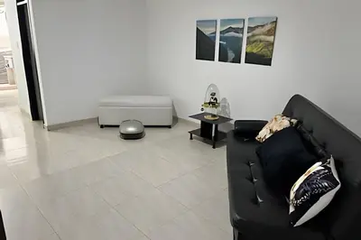 a living room with a black couch and a table at Casa Acogedora y Amplia - Estrato 5 in Manizales