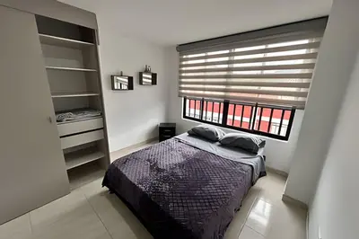 a bedroom with a bed and a large window at Casa Acogedora y Amplia - Estrato 5 in Manizales