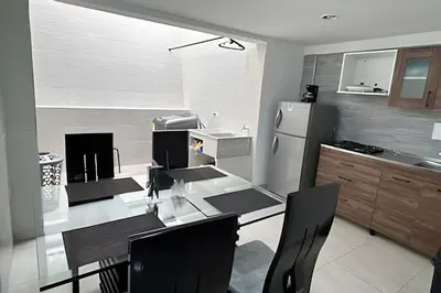 a kitchen with a table and a refrigerator at Casa Acogedora y Amplia - Estrato 5 in Manizales