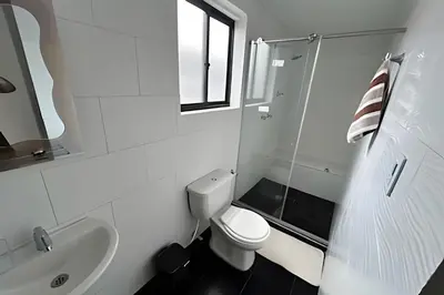 a white bathroom with a toilet and a sink at Casa Acogedora y Amplia - Estrato 5 in Manizales
