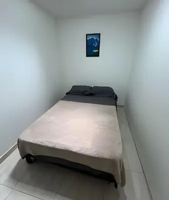 a bed in a room with a white wall at Casa Acogedora y Amplia - Estrato 5 in Manizales
