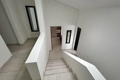 a staircase in a house with white walls at Casa Acogedora y Amplia - Estrato 5 in Manizales