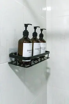 a shelf in a bathroom with three bottles on it at Charming scape cozy and stylish N Medellin in Medellín