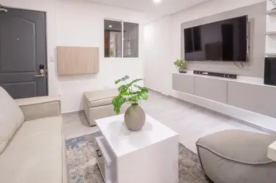a living room with a couch and a tv at Charming scape cozy and stylish N Medellin in Medellín