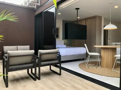a bedroom with a bed and two chairs and a table at Cozy Studio in Laureles MDE in Medellín