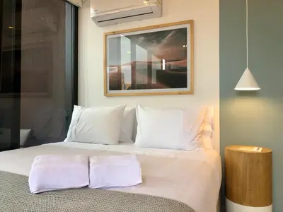 a bed with white sheets and pillows in a room at Cozy Studio in Laureles MDE in Medellín