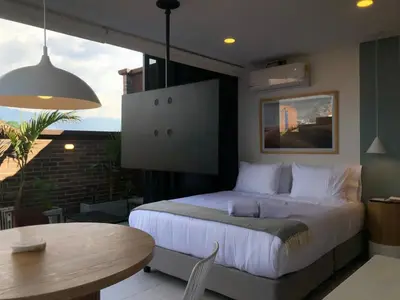 a bedroom with a bed and a table in a room at Cozy Studio in Laureles MDE in Medellín