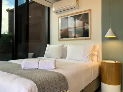 a bedroom with a large bed with white pillows at Cozy Studio in Laureles MDE in Medellín