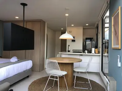 a small room with a bed and a table and chairs at Cozy Studio in Laureles MDE in Medellín