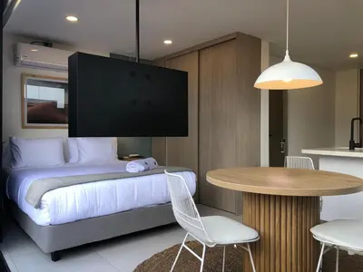 a bedroom with a bed and a table with chairs at Cozy Studio in Laureles MDE in Medellín