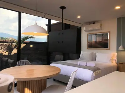 a bedroom with a large bed and a table at Cozy Studio in Laureles MDE in Medellín