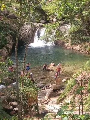 a group of people standing in a river with a waterfall at Glasshouse with river in San Rafael