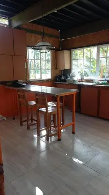 a kitchen with a large wooden table and chairs at Glasshouse with river in San Rafael