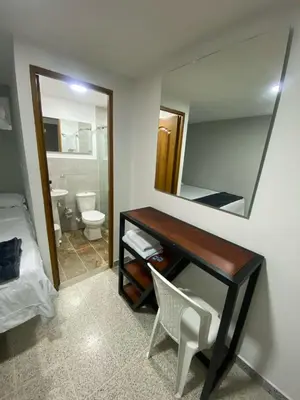a bathroom with a desk with a mirror and a toilet at Hotel Don Pacho in Los Andes