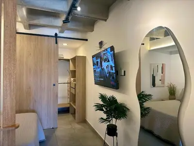 a room with a tv on the wall and a bedroom at Apartaestudio en el Corazón del Oriente Antioqueño in La Ceja