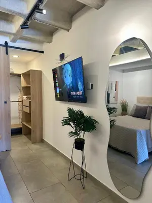 a bedroom with a bed and a tv on a wall at Apartaestudio en el Corazón del Oriente Antioqueño in La Ceja