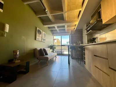 a living room with a couch and a table and a kitchen at Apartaestudio en el Corazón del Oriente Antioqueño in La Ceja