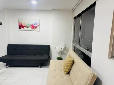 a living room with a black couch and a window at Gran loft cerca al tesoro y al lleras 121 in Medellín