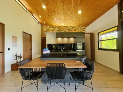 a kitchen with a large wooden table and chairs at Los Pinos in Guatapé
