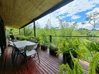 a deck with a table and chairs and plants at Los Pinos in Guatapé