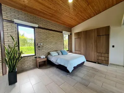 a bedroom with a bed and a brick wall at Los Pinos in Guatapé