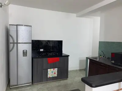 a kitchen with a stainless steel refrigerator and a counter at Apartamento a 5 minuto de hacienda napoles y el santorine colombiano in Doradal