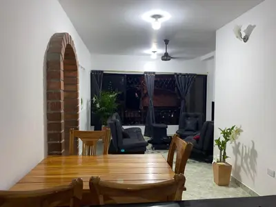 a living room with a wooden table and chairs at Apartamento a 5 minuto de hacienda napoles y el santorine colombiano in Doradal