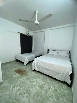 a room with two beds and a ceiling fan at Apartamento a 5 minuto de hacienda napoles y el santorine colombiano in Doradal