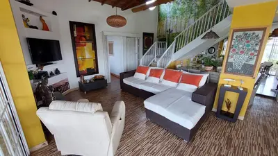 a living room with white furniture and a staircase at Finca Con Hermosa Vista a la Piedra del Peñol y Jacuzzi Grande in El Peñol