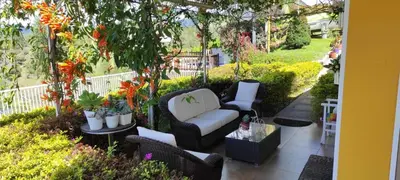 a patio with a couch and chairs in a garden at Finca Con Hermosa Vista a la Piedra del Peñol y Jacuzzi Grande in El Peñol