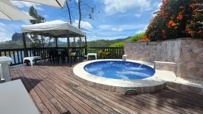 a hot tub on a deck with a table and chairs at Finca Con Hermosa Vista a la Piedra del Peñol y Jacuzzi Grande in El Peñol