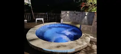 a blue pool with a white chair in a backyard at Finca Con Hermosa Vista a la Piedra del Peñol y Jacuzzi Grande in El Peñol