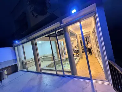 a person standing in a room with glass windows at Villa Entre Nubes in El Hatillo