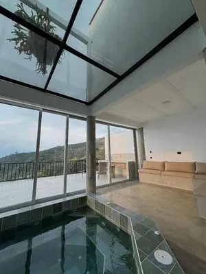 a room with a pool with a view of the ocean at Villa Entre Nubes in El Hatillo